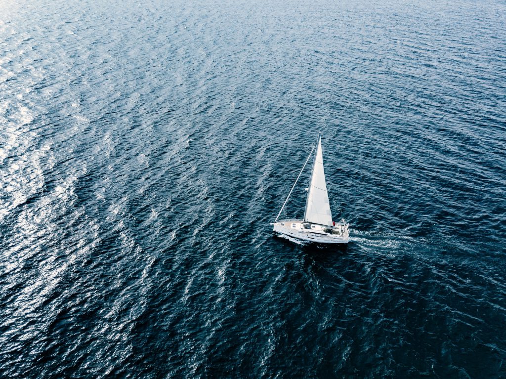 Aerial view of Sailing ship yachts with white sails in deep blue sea