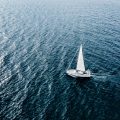 Aerial view of Sailing ship yachts with white sails in deep blue sea