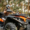 Two quad bike riders in helmets closeup, side view
