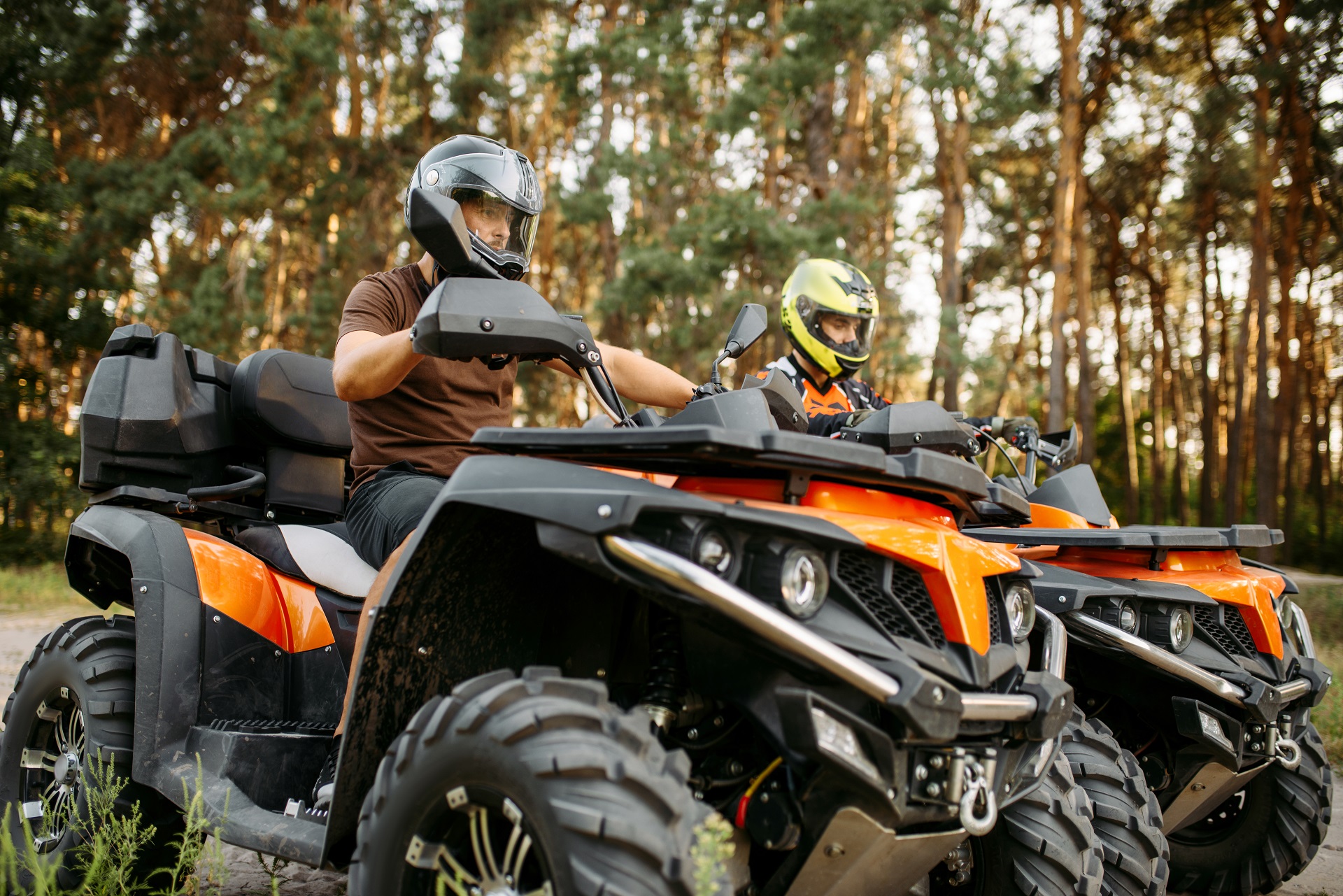 Two quad bike riders in helmets closeup, side view
