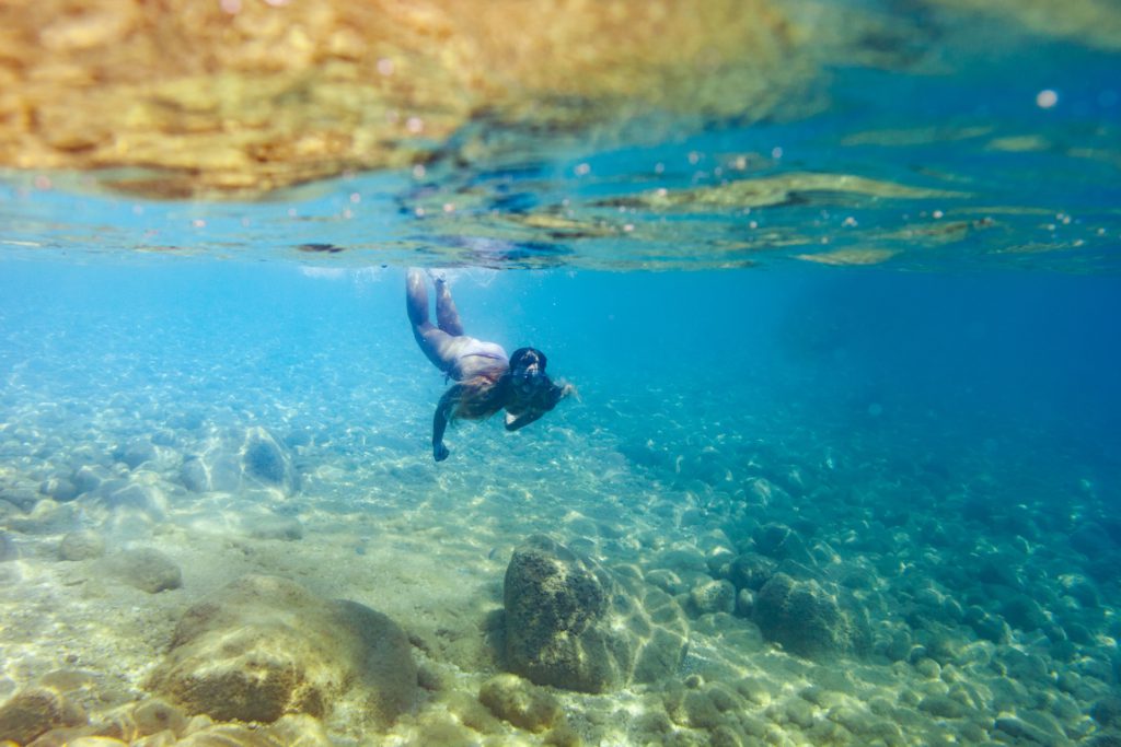 Young woman snorkeling and diving in tropical sea